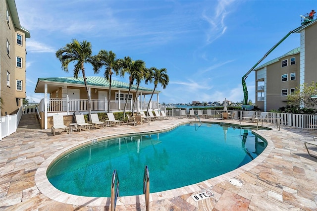 pool with a patio area and fence