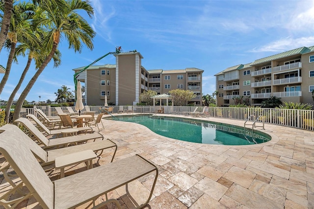 community pool featuring fence and a patio