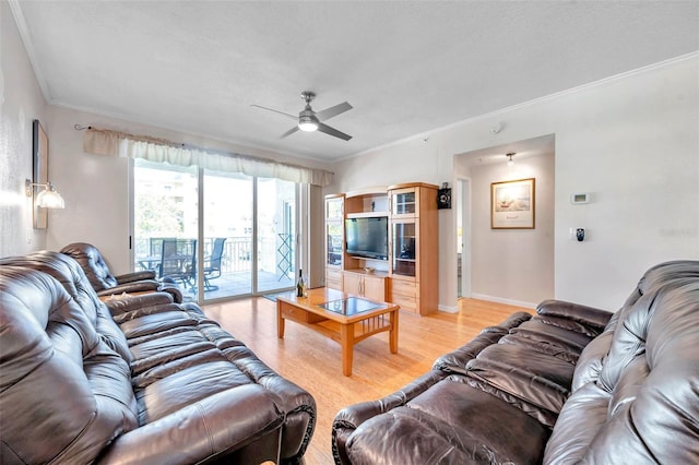 living area featuring light wood-type flooring, ceiling fan, baseboards, and crown molding