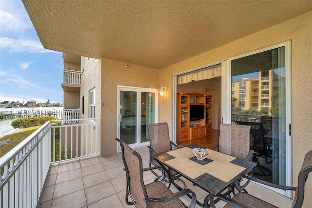 balcony featuring a water view and outdoor dining space