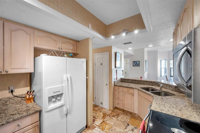 kitchen with visible vents, backsplash, light brown cabinets, a sink, and white fridge with ice dispenser