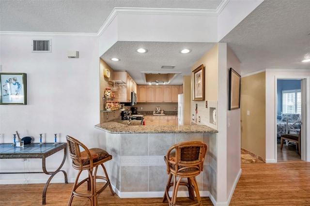 kitchen featuring ornamental molding, visible vents, light wood-style flooring, and electric range oven