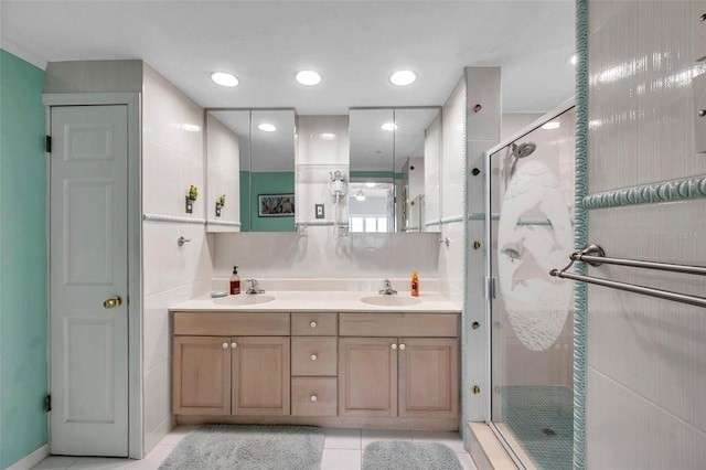 bathroom with tile patterned flooring, a sink, a shower stall, and double vanity