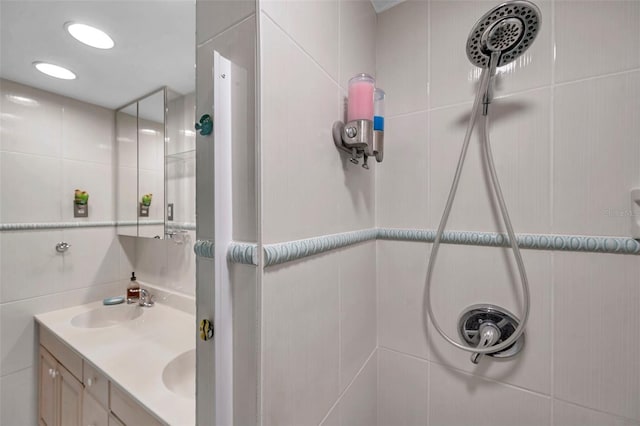 full bath with tile walls, a sink, and tiled shower