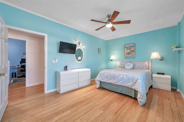 bedroom with a ceiling fan, light wood-style flooring, and baseboards