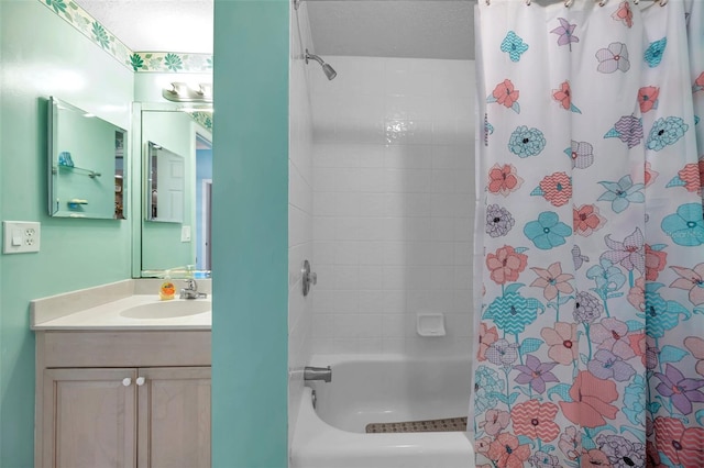 full bath with shower / bath combination with curtain, vanity, and a textured ceiling