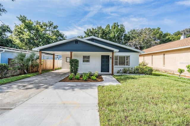 ranch-style home featuring a front lawn and a carport