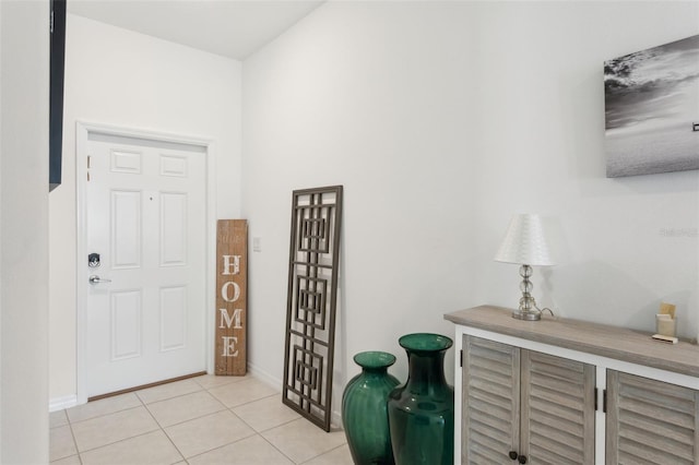 entryway with light tile patterned floors and baseboards