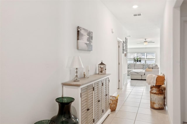 hallway featuring light tile patterned floors and visible vents