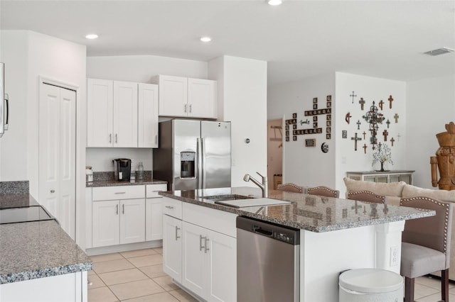 kitchen featuring sink, stainless steel appliances, white cabinets, and a center island with sink