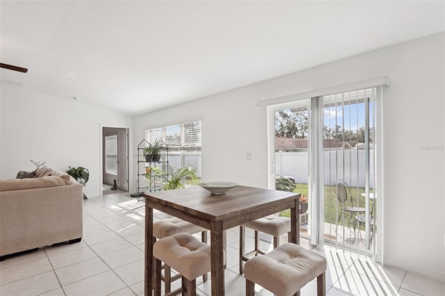 dining space featuring vaulted ceiling and light tile patterned floors