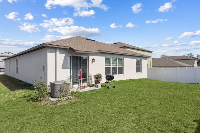 back of house with central air condition unit, stucco siding, a lawn, fence, and roof with shingles