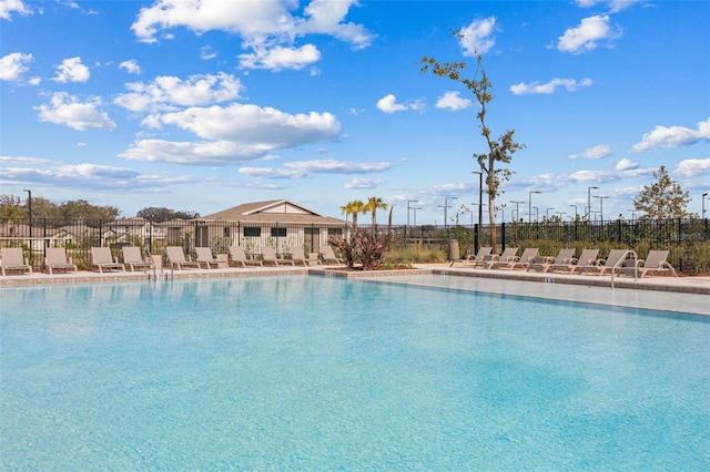 community pool with a patio and fence