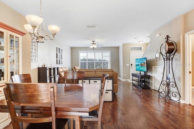 dining room with dark hardwood / wood-style flooring and ceiling fan with notable chandelier