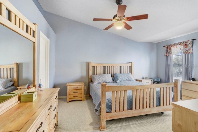 bedroom featuring vaulted ceiling, light colored carpet, and ceiling fan