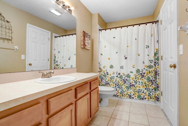 bathroom featuring vanity, tile patterned floors, and toilet