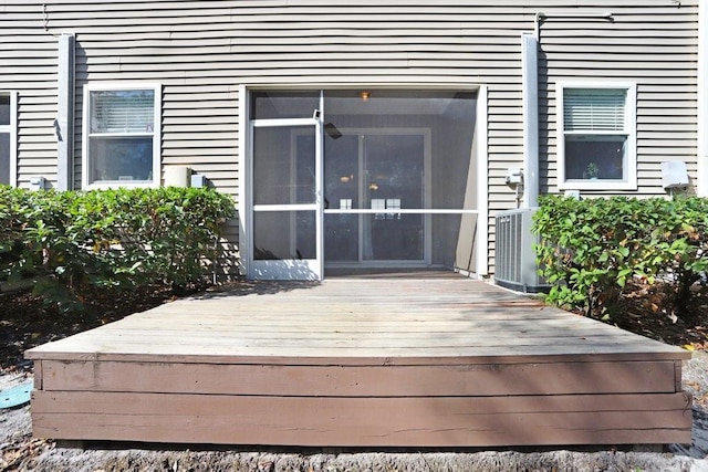 view of exterior entry featuring central AC and a deck