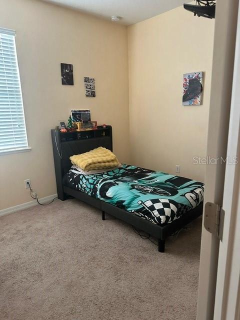 bedroom with baseboards and carpet flooring