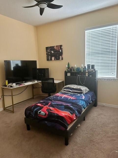 bedroom with ceiling fan, carpet floors, and baseboards