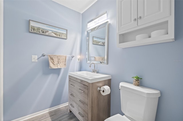 bathroom featuring hardwood / wood-style flooring, vanity, and toilet