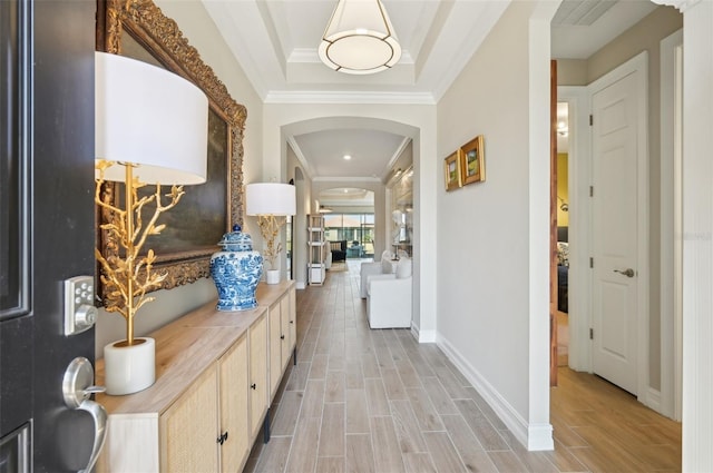 hallway featuring ornamental molding and a tray ceiling