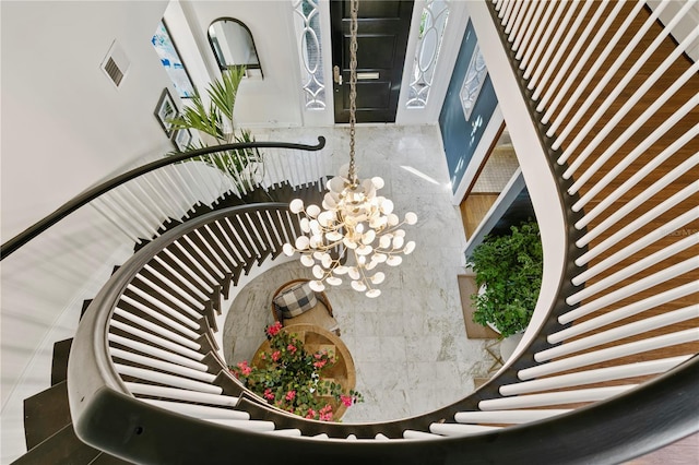 staircase with an inviting chandelier