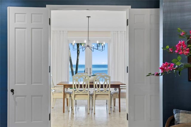 dining space with a notable chandelier and a water view