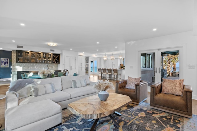 living room with wood-type flooring, french doors, and indoor bar