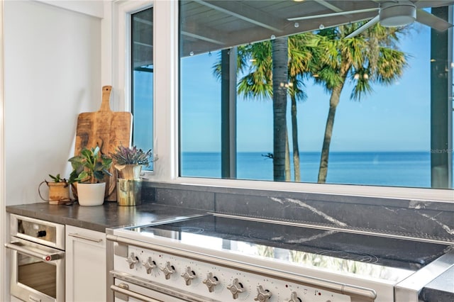 kitchen featuring stainless steel appliances, a water view, and white cabinets