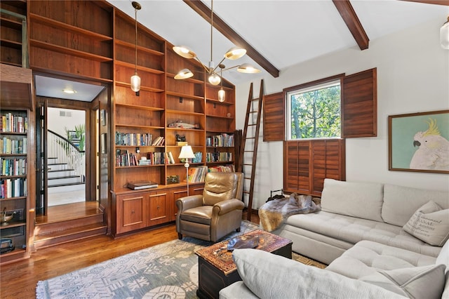 living room with a notable chandelier, hardwood / wood-style floors, and vaulted ceiling with beams