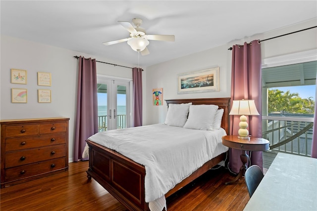 bedroom with dark hardwood / wood-style floors, access to exterior, ceiling fan, a water view, and french doors