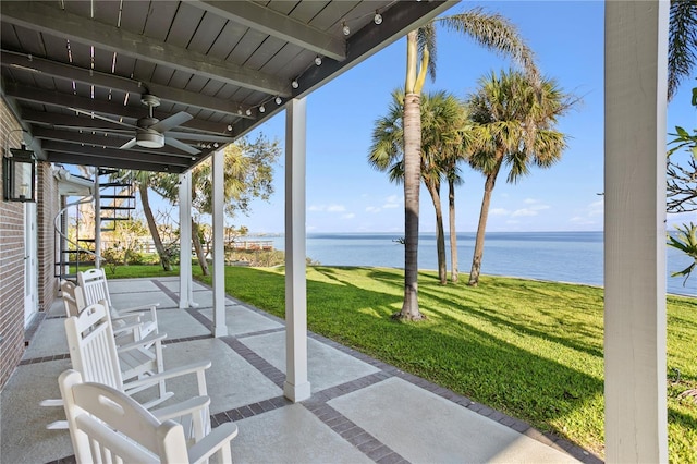 view of patio with a water view and ceiling fan