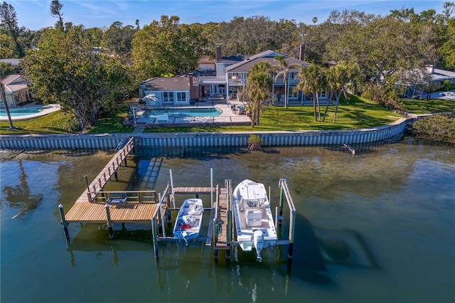 view of dock with a yard, a swimming pool, and a water view