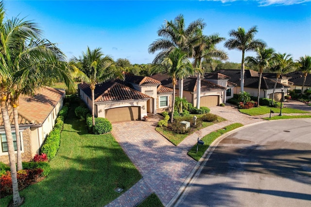 mediterranean / spanish-style home featuring a garage and a front lawn