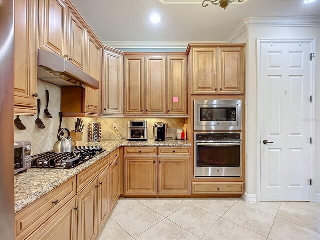 kitchen with light stone counters, appliances with stainless steel finishes, light tile patterned floors, and backsplash