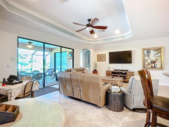 tiled living room featuring crown molding, a raised ceiling, and ceiling fan