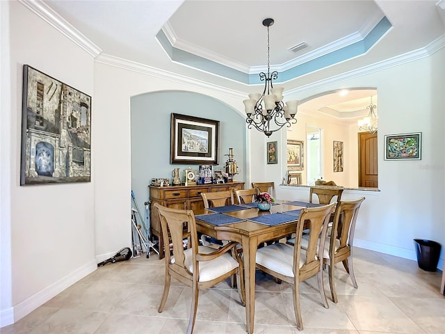 dining room featuring ornamental molding, a raised ceiling, light tile patterned floors, and a notable chandelier