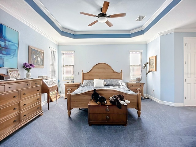 carpeted bedroom with ornamental molding and a raised ceiling