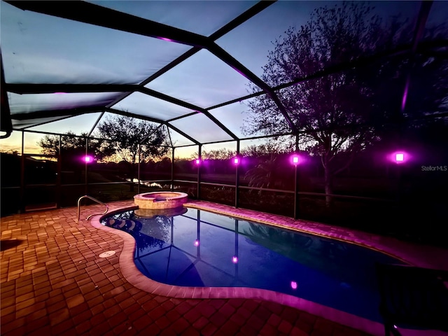 pool at dusk featuring an in ground hot tub, a lanai, and a patio