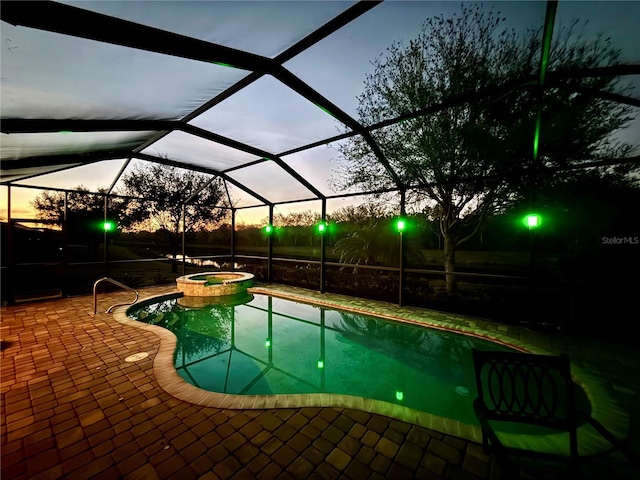 pool at dusk featuring a patio, glass enclosure, and an in ground hot tub