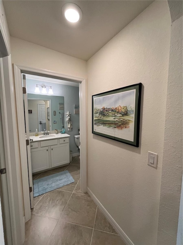 bathroom featuring vanity, tile patterned flooring, and toilet