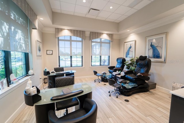 office space featuring a tray ceiling, a drop ceiling, and light wood-type flooring