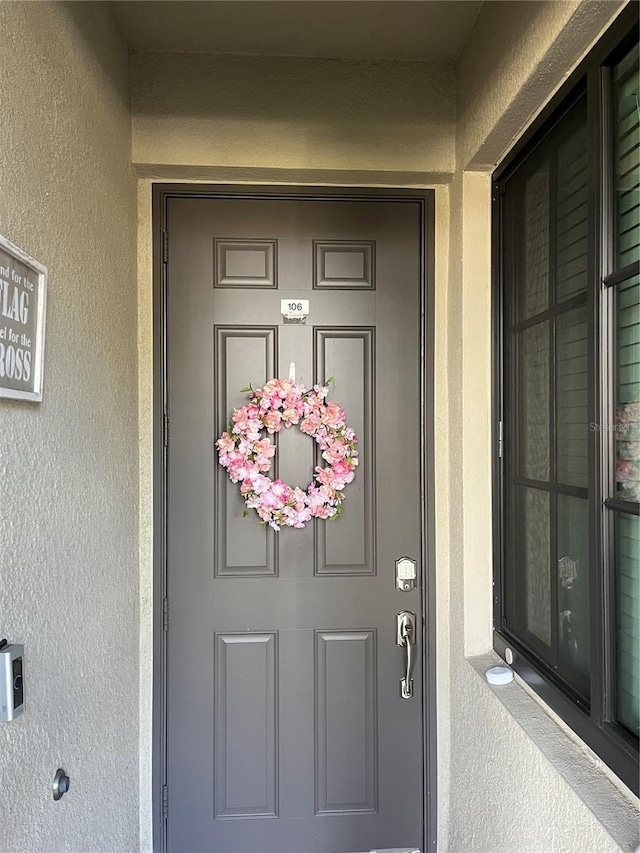 view of exterior entry featuring stucco siding