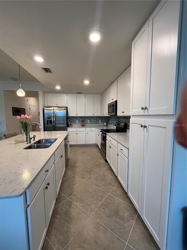 kitchen featuring visible vents, hanging light fixtures, appliances with stainless steel finishes, white cabinetry, and a sink