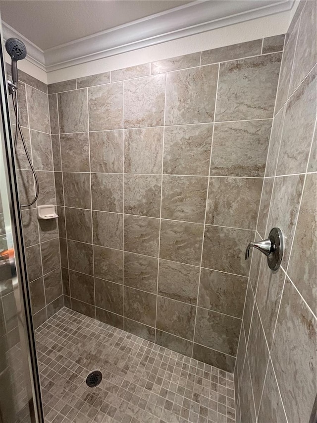 full bath with ornamental molding and a stall shower