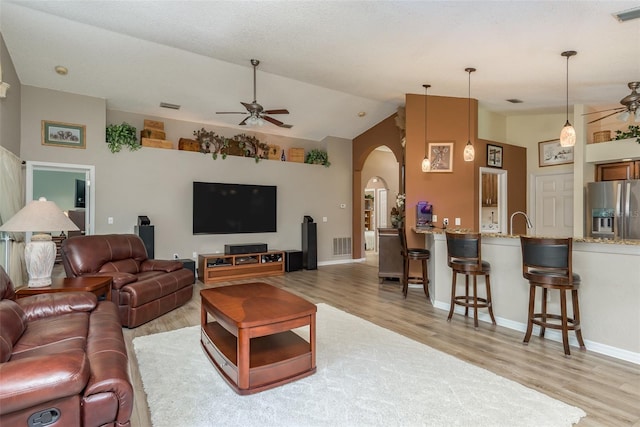 living room with vaulted ceiling, ceiling fan, and light hardwood / wood-style floors