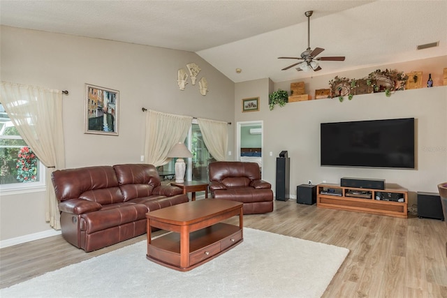 living room with vaulted ceiling, wood-type flooring, a textured ceiling, and ceiling fan