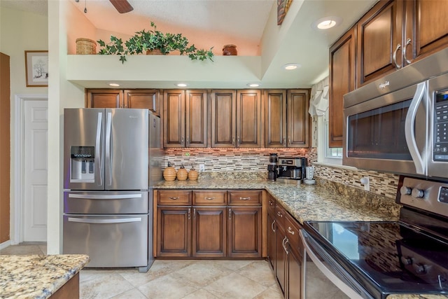 kitchen featuring light stone counters, tasteful backsplash, stainless steel appliances, and light tile patterned flooring