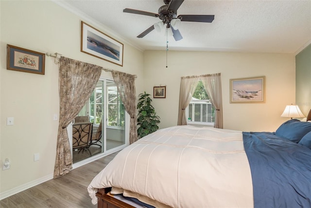 bedroom with ceiling fan, lofted ceiling, wood-type flooring, and a textured ceiling