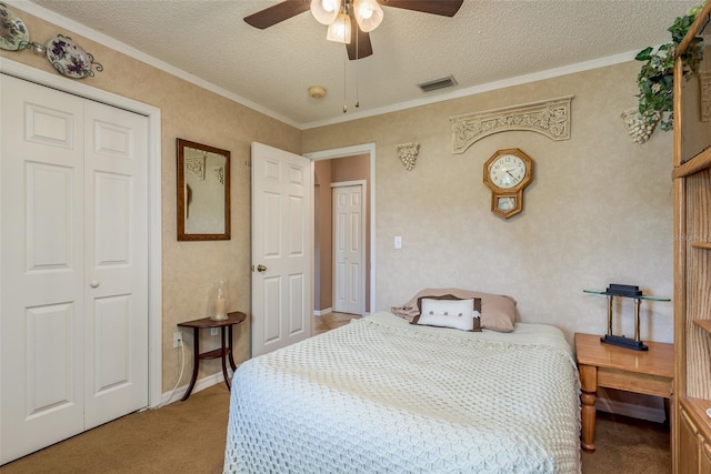 carpeted bedroom featuring ceiling fan, ornamental molding, a closet, and a textured ceiling